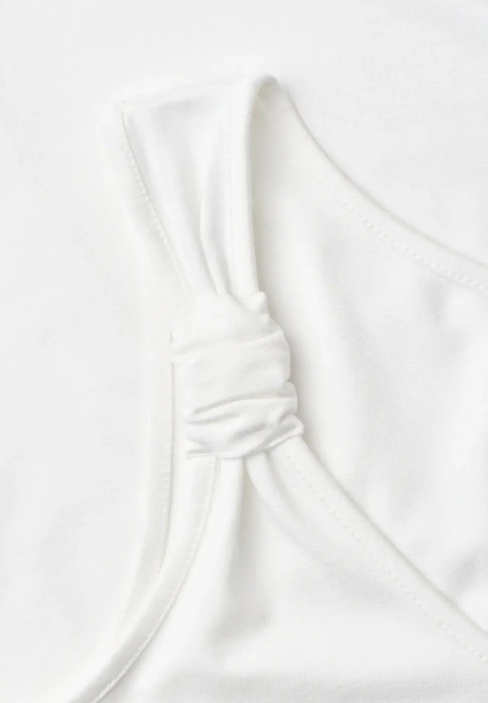 Top met V-hals en knoopdetail